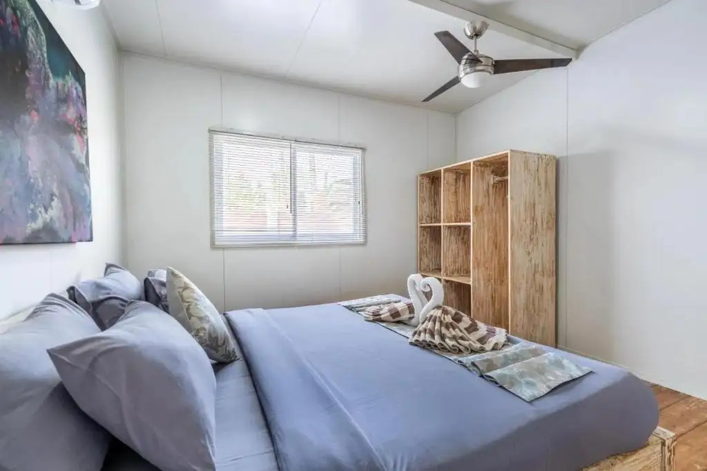 Bedroom with ceiling fan and teak wardrobe