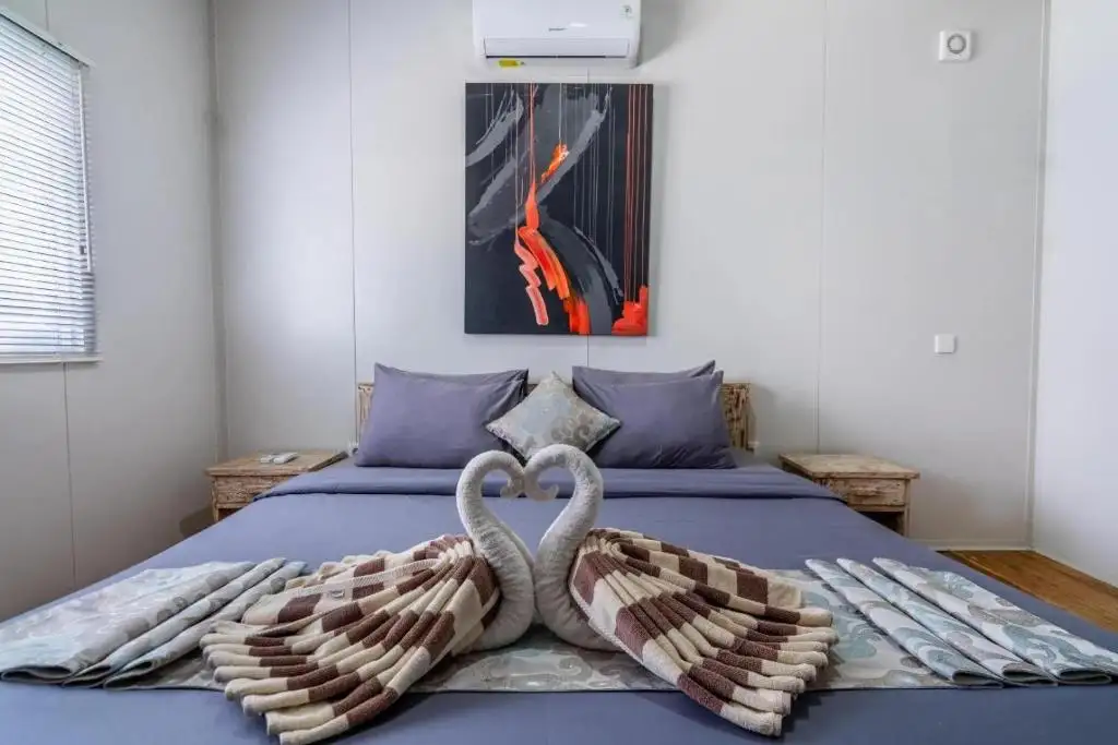 Double bed with towel swans and painting